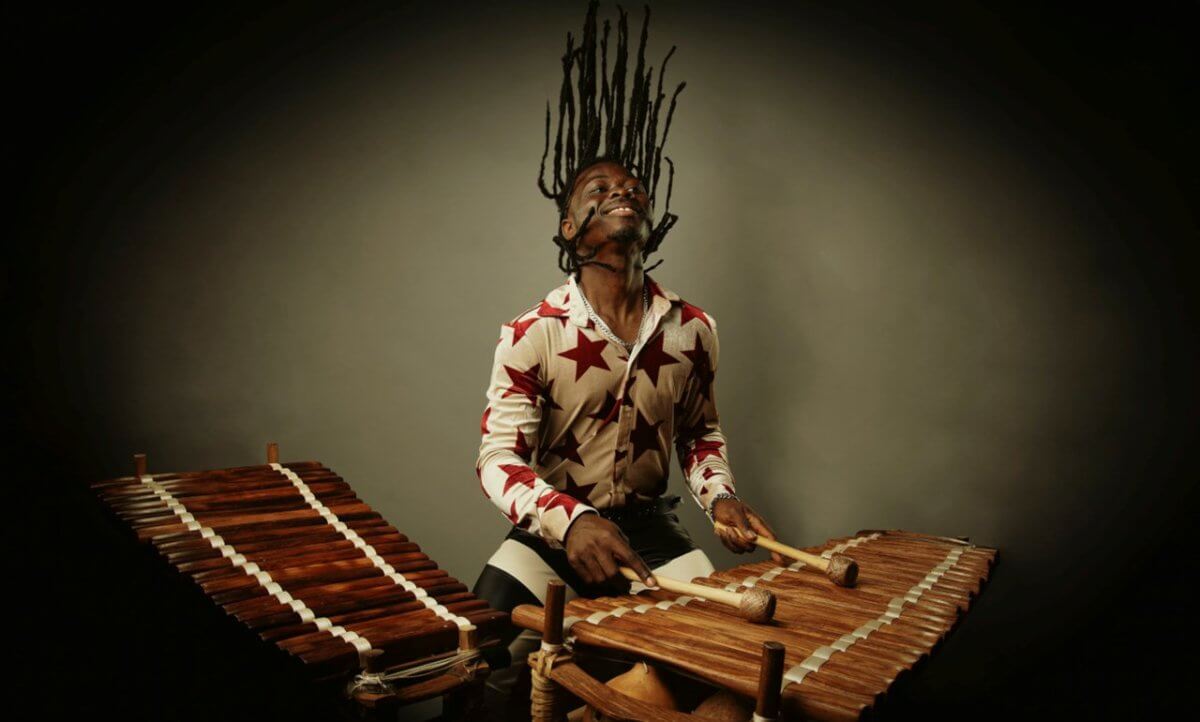 A performer playing a wooden percussive instrument.