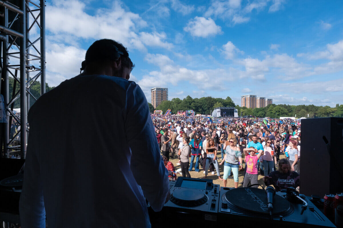 A DJ performing to a festival crowd.